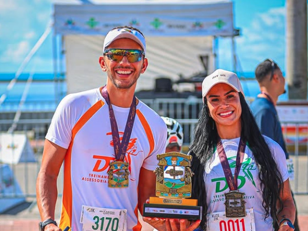 Wendel De Deus e uma atleta da DD Treinamento comemorando com medalhas e troféu